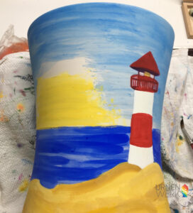Der Himmel wurde auf die Urne aufgetragen und der Leuchtturm ausgemalt in Rot und Weiß.