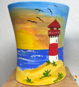 Wellen befinden sich auf dem Meer, Möwen umkreisen den Leuchtturm und Gräser sind auf dem Sand.